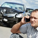 Adult upset driver man discussing on mobile phone in front of automobile crash car collision accident in city road